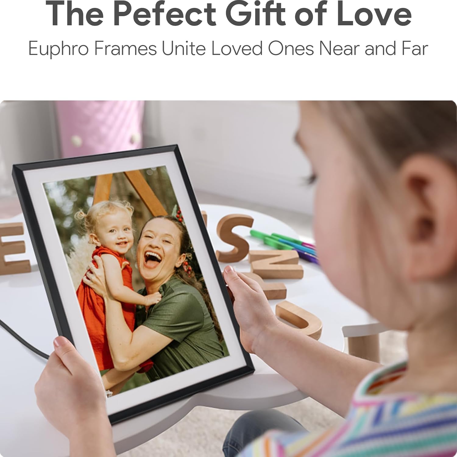 WiFi digital picture frame for families showing a child holding a frame with a photo of a smiling mother and child